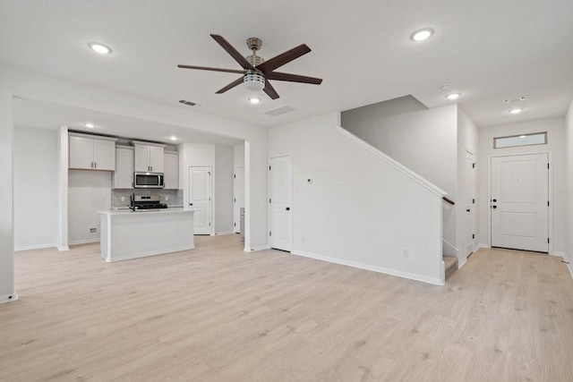 unfurnished living room with light hardwood / wood-style floors and ceiling fan