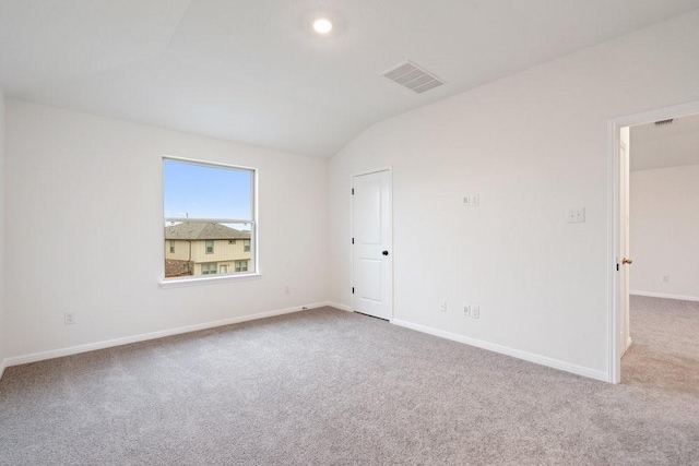 empty room featuring light colored carpet and lofted ceiling