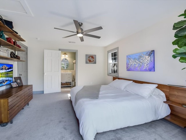 carpeted bedroom featuring ceiling fan and ensuite bath