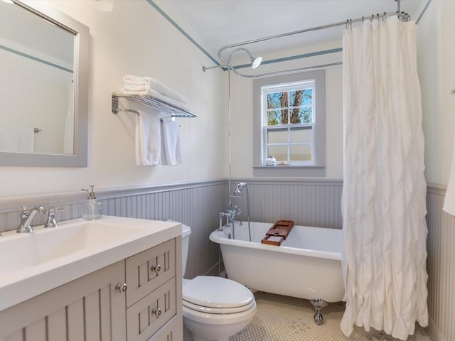 bathroom featuring tile patterned floors, a tub, vanity, and toilet