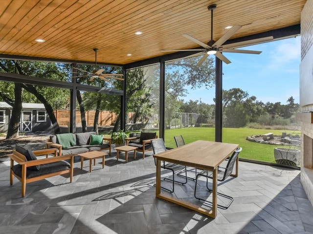 sunroom / solarium featuring ceiling fan and wood ceiling