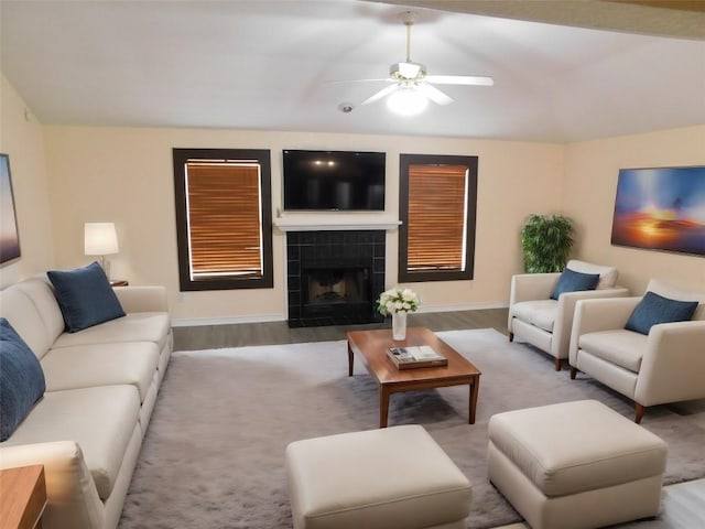 living room with hardwood / wood-style flooring, ceiling fan, and a fireplace