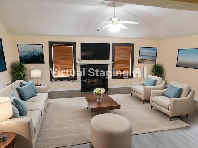 living room with a fireplace, ceiling fan, and hardwood / wood-style floors