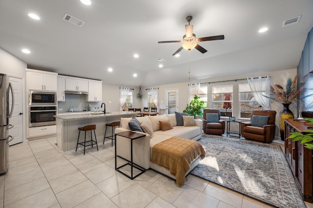 living room with ceiling fan, sink, a healthy amount of sunlight, and lofted ceiling