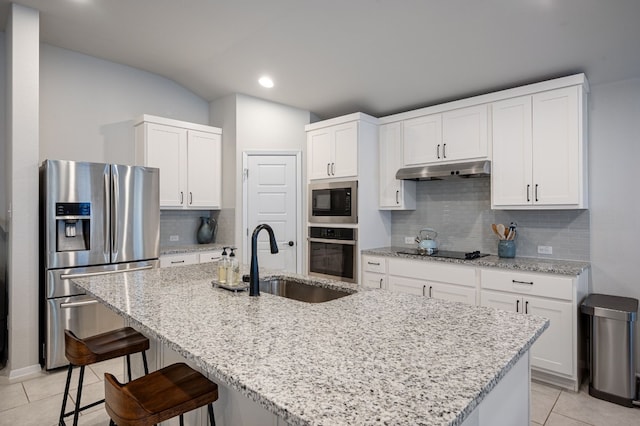 kitchen featuring white cabinetry, sink, stainless steel appliances, a center island with sink, and light tile patterned floors