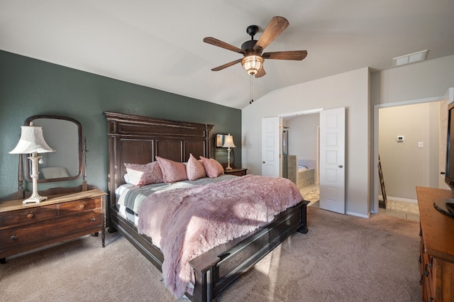 carpeted bedroom with ceiling fan, ensuite bathroom, and vaulted ceiling