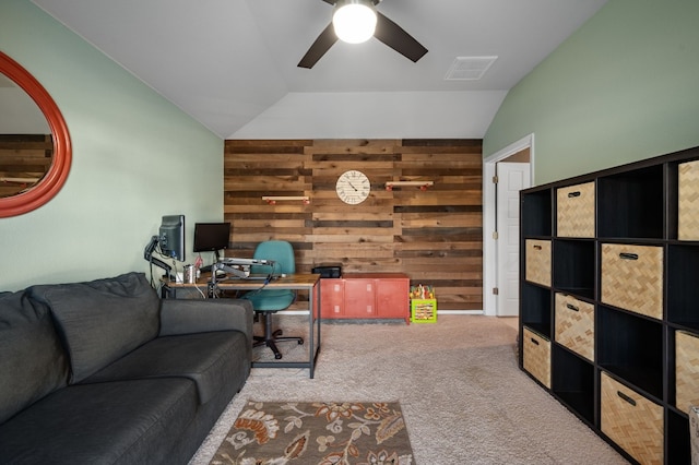 carpeted office space with ceiling fan, wood walls, and vaulted ceiling