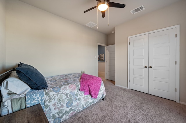 bedroom with ceiling fan, light carpet, and a closet