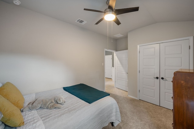 carpeted bedroom featuring ceiling fan, lofted ceiling, and a closet