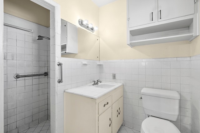 901 Berrywood Dr, Austin, TX 78753 - bathroom with a tile shower, toilet, vanity, a wainscoted wall, and tile walls