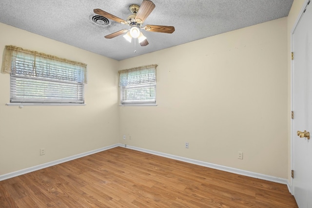 unfurnished room with ceiling fan, a textured ceiling, and light hardwood / wood-style flooring