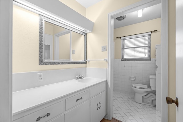 901 Berrywood Dr, Austin, TX 78753 - bathroom featuring toilet, tile walls, vanity, wainscoting, and tile patterned flooring