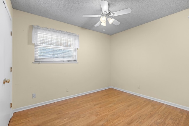 spare room featuring ceiling fan, light hardwood / wood-style floors, and a textured ceiling