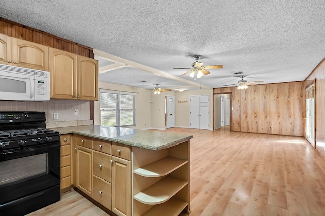 kitchen featuring black range with gas stovetop, kitchen peninsula, dark stone counters, and light hardwood / wood-style flooring