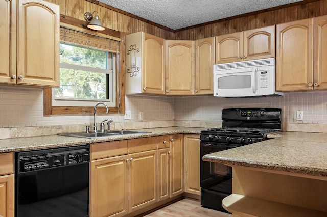 kitchen with backsplash, black appliances, sink, light hardwood / wood-style flooring, and light stone countertops