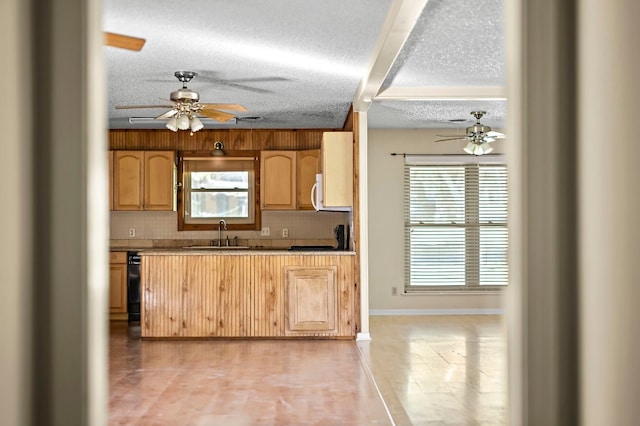 kitchen featuring decorative backsplash, a textured ceiling, and sink