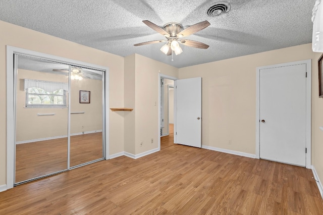 901 Berrywood Dr, Austin, TX 78753 - unfurnished bedroom with light wood-type flooring, baseboards, a closet, a ceiling fan, and a textured ceiling