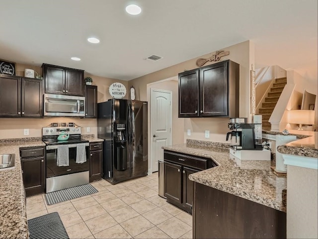 kitchen with dark brown cabinets, light stone countertops, and appliances with stainless steel finishes