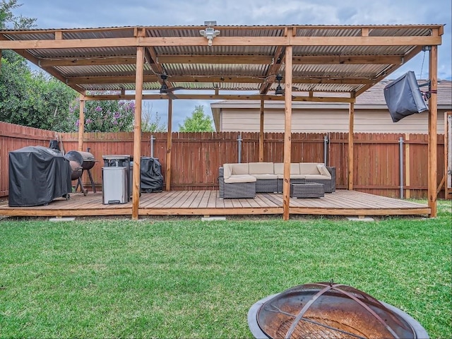 wooden terrace with grilling area, a yard, and an outdoor living space with a fire pit