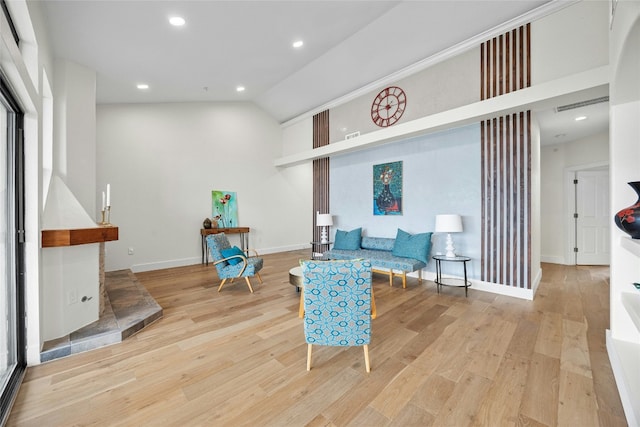 sitting room with light wood-type flooring and vaulted ceiling