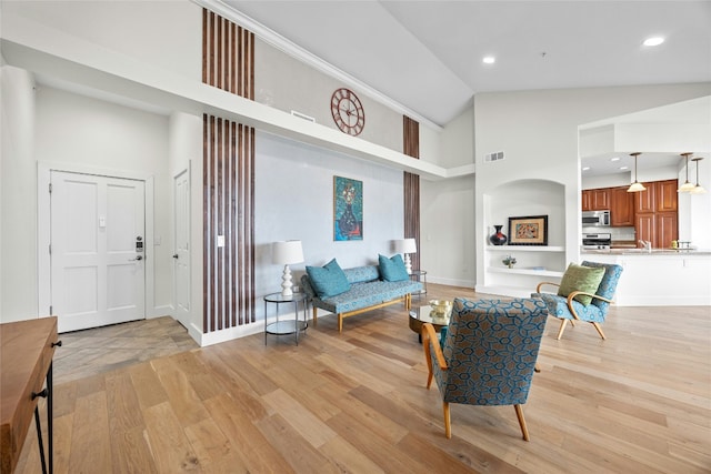 living room featuring high vaulted ceiling, light wood-type flooring, and sink