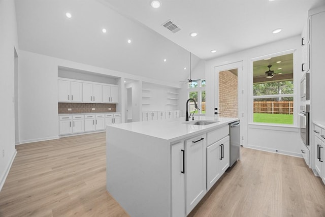 6000 Sean Paul Ln, Georgetown, TX 78628 - kitchen featuring a ceiling fan, stainless steel appliances, an island with sink, white cabinets, and lofted ceiling