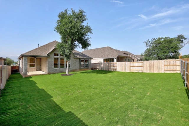 6000 Sean Paul Ln, Georgetown, TX 78628 - rear view of house featuring a fenced backyard, a patio, brick siding, and a shingled roof