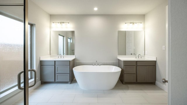 5612 Kyle Joseph Dr, Georgetown, TX 78628 - full bath featuring two vanities, a freestanding tub, a stall shower, tile patterned floors, and recessed lighting