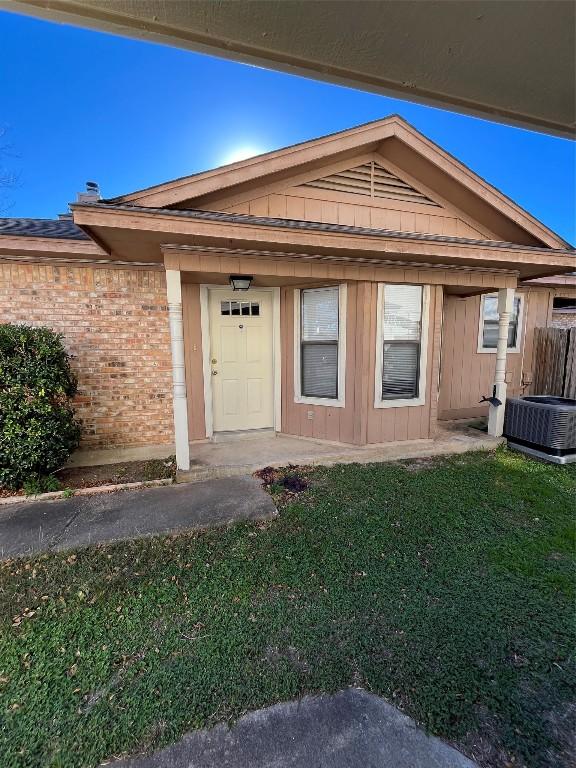 property entrance with a lawn and central AC