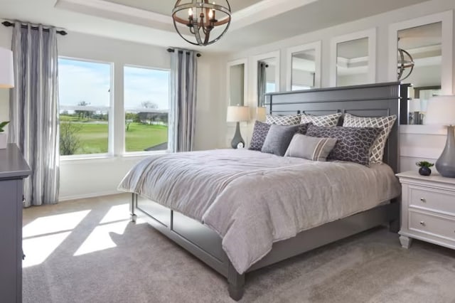 bedroom featuring a chandelier, multiple windows, and a tray ceiling