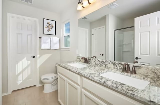 bathroom with tile patterned flooring, vanity, toilet, and a shower with shower door