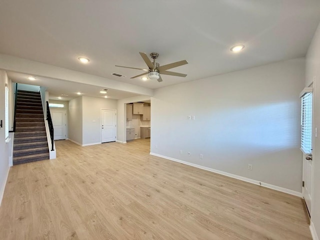 unfurnished living room featuring ceiling fan and light hardwood / wood-style flooring