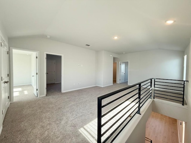 carpeted spare room with lofted ceiling