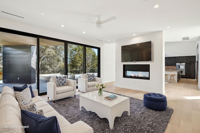 living room featuring light wood-type flooring and ceiling fan