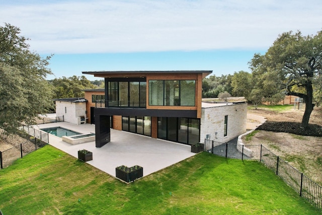 back of house with a pool with hot tub, a patio area, and a lawn