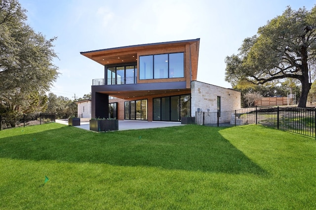 back of property featuring a lawn, a balcony, and a patio