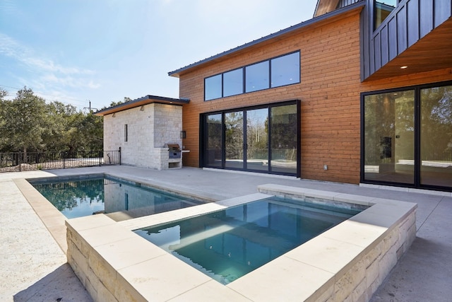 view of swimming pool featuring an in ground hot tub and a patio