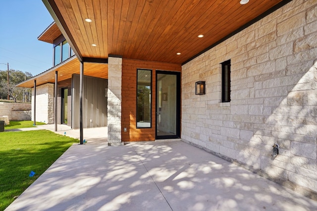 doorway to property with a yard and a patio