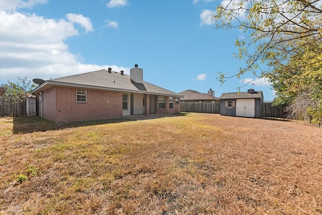 back of property featuring a yard and a shed