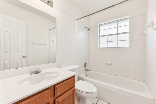 full bathroom with tile patterned floors, vanity, tiled shower / bath combo, and toilet