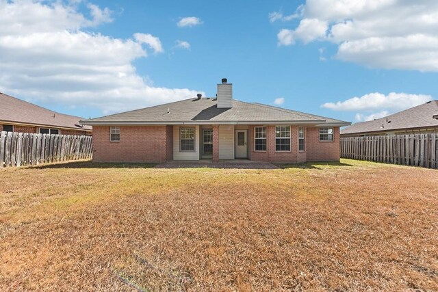 rear view of house featuring a lawn