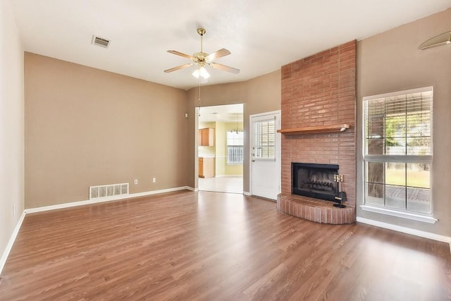 unfurnished living room with ceiling fan, wood-type flooring, and a fireplace