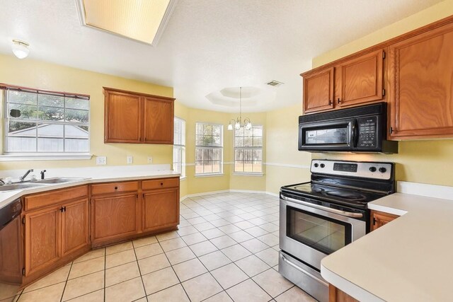 kitchen with sink, hanging light fixtures, a chandelier, light tile patterned floors, and appliances with stainless steel finishes