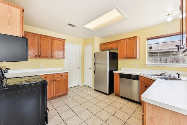 kitchen featuring sink, light tile patterned flooring, and black appliances