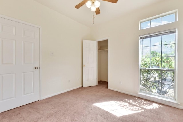 unfurnished bedroom featuring a closet, light colored carpet, and ceiling fan