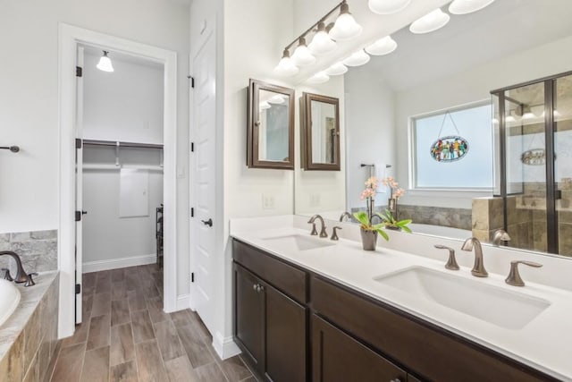 bathroom with vanity and tiled tub