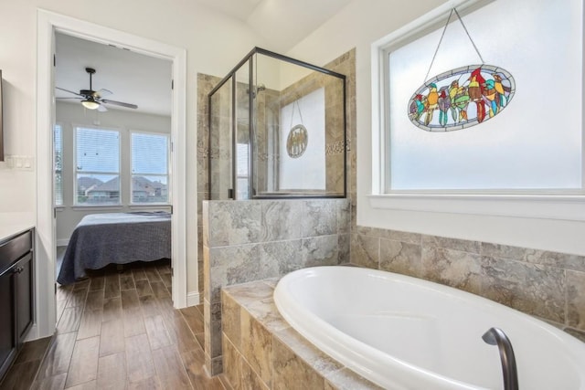 bathroom featuring ceiling fan, vanity, and plus walk in shower