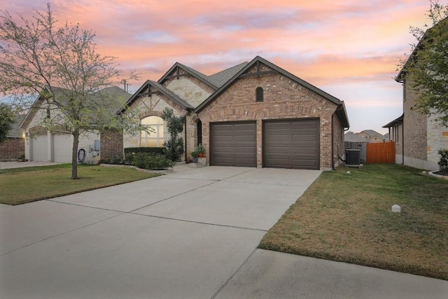 view of front facade featuring a lawn, cooling unit, and a garage