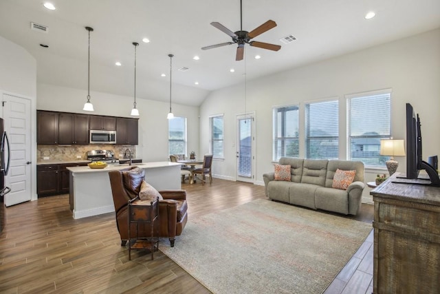 living room featuring dark hardwood / wood-style floors, ceiling fan, lofted ceiling, and sink