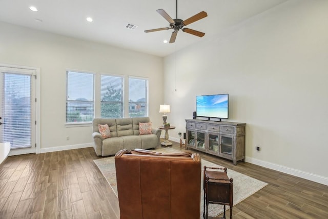 living room featuring ceiling fan and dark wood-type flooring